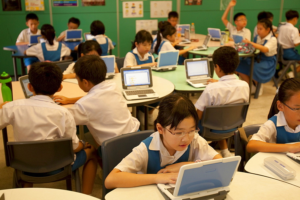 Schoolchildren in 3rd grade at the Canberra Public Primary School use laptops during a summer vacation enrichment class in English.