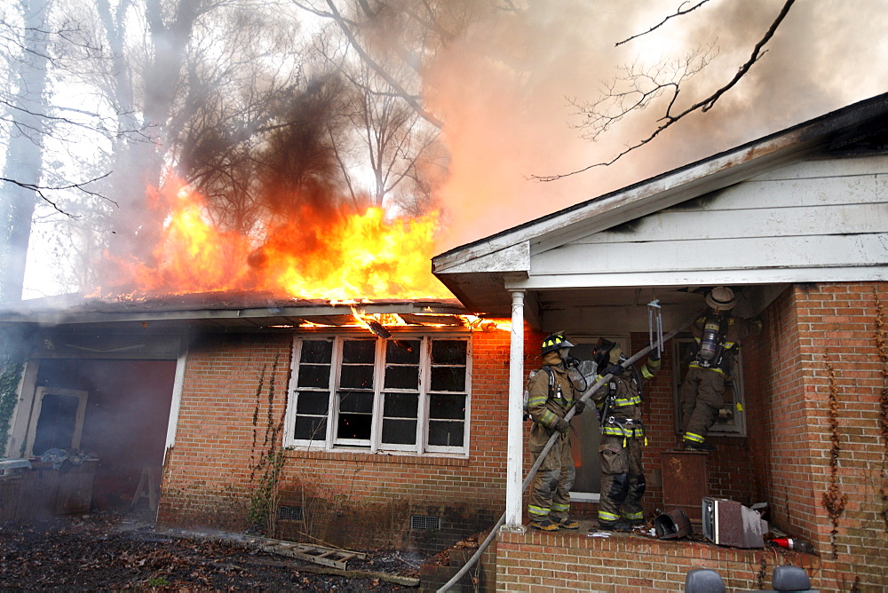 Firefighters extinguishing house fire