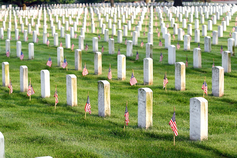 Soldiers place flags on graves at Arlington National Cemetery.