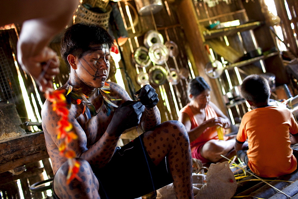 Members of the Oro Win tribe make preparations and body decorations for an upcoming traditional "festa" or celebration, Sao Luis Indian Post, Brazil.