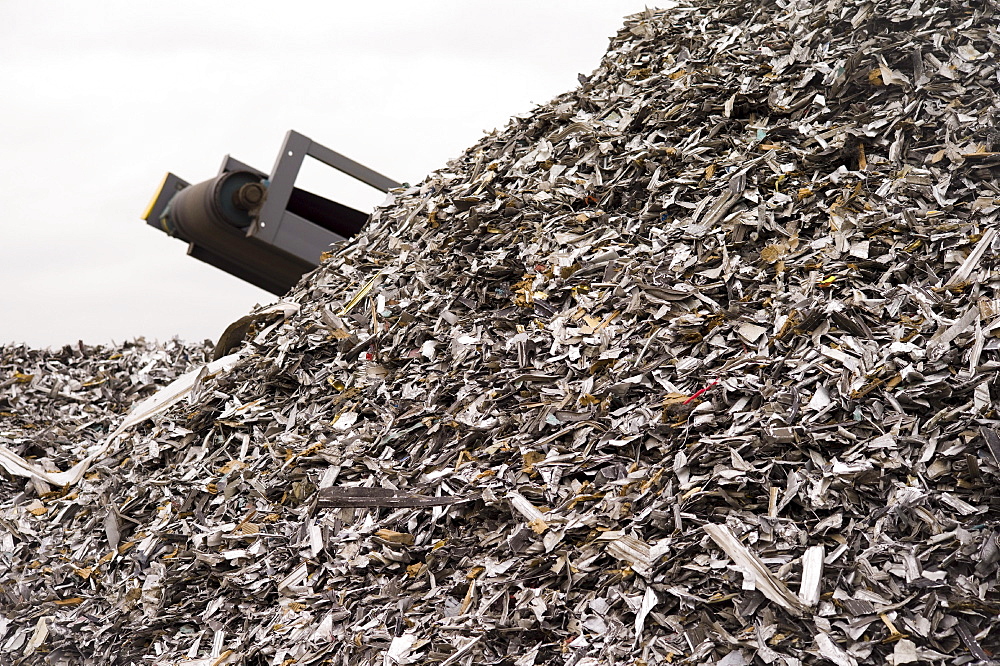 Workers at Atlas Metal & Iron weigh scrap metal for sale on a scale in their vast Denver yard.