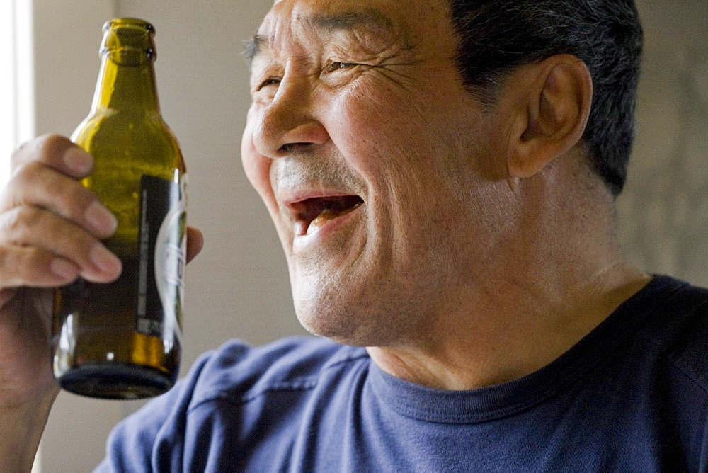 A man drinking beer in the morning in his home in Qaqortoq, Greenland