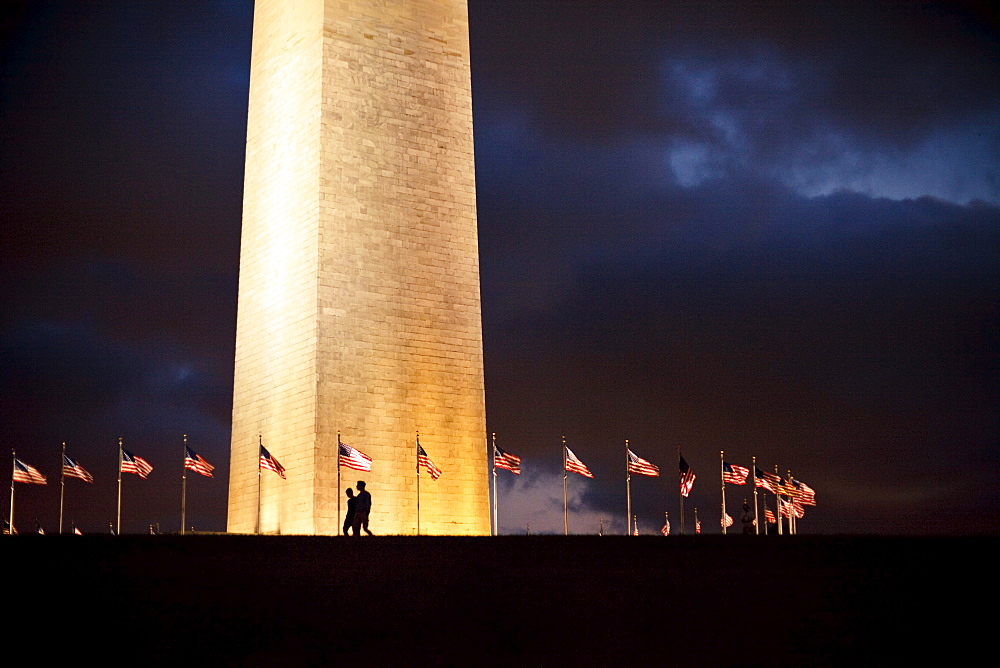 Two People walking by the Washington Monument.