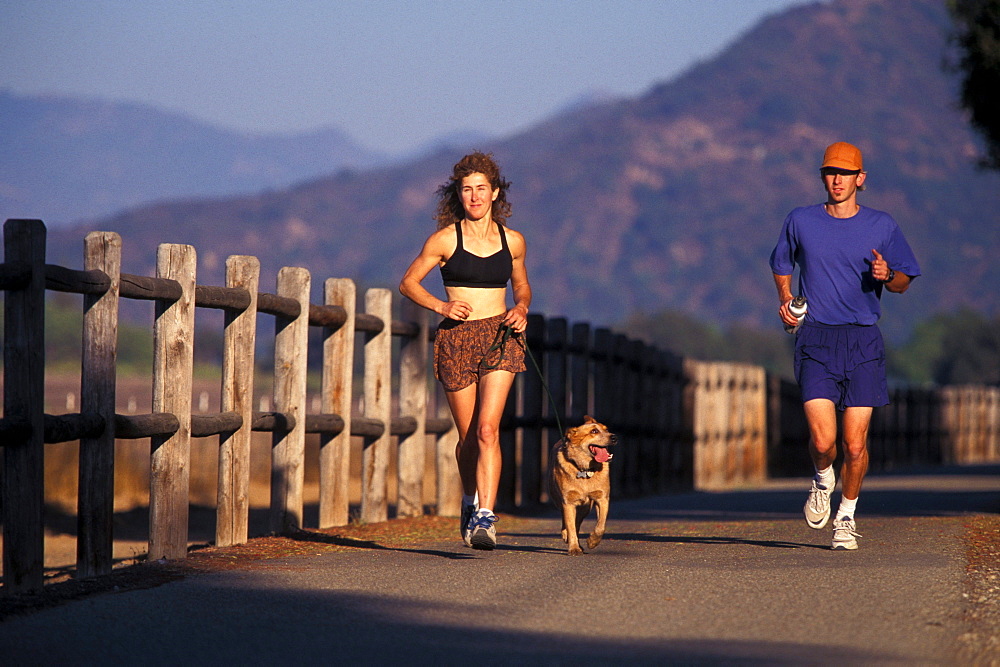 Lynne Siodmak, Brian Crowder  and Evie run on the Ojai Valley Trail along the ocean in Ojai, California.