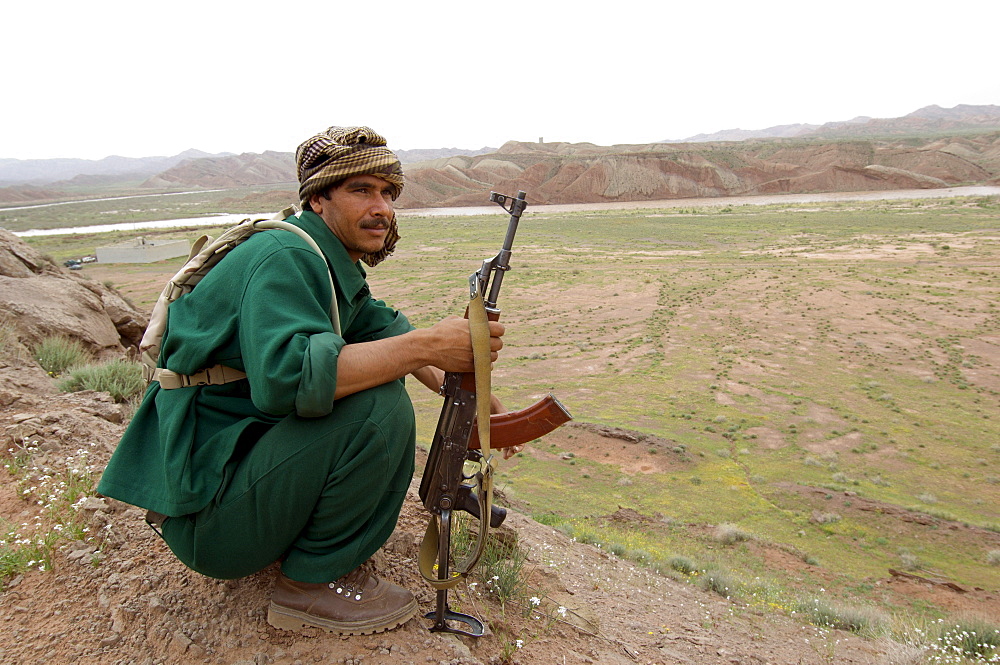 A border policeman looks out form a ridge, at a post on the Hari Rud River, with Iran just on the other side, in Gulran District, in the northwest part of Herat Province.