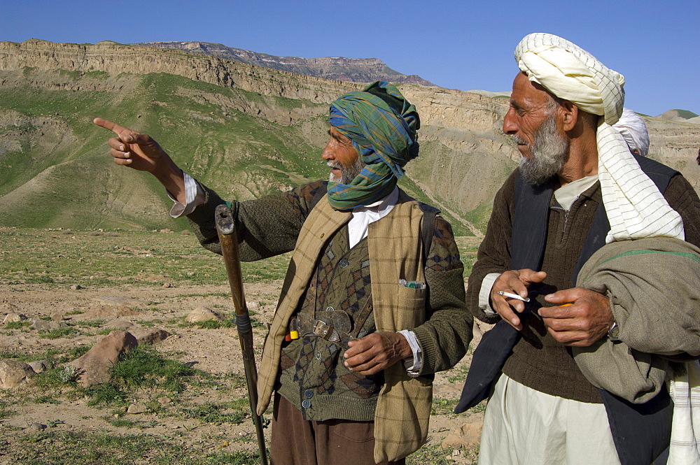 A local hunter, Abdul Rahim, points out mountains where ibex are found, to the village headman, Nur Ahmed, in the Band-e Baba range, Herat Province, Afghanistan