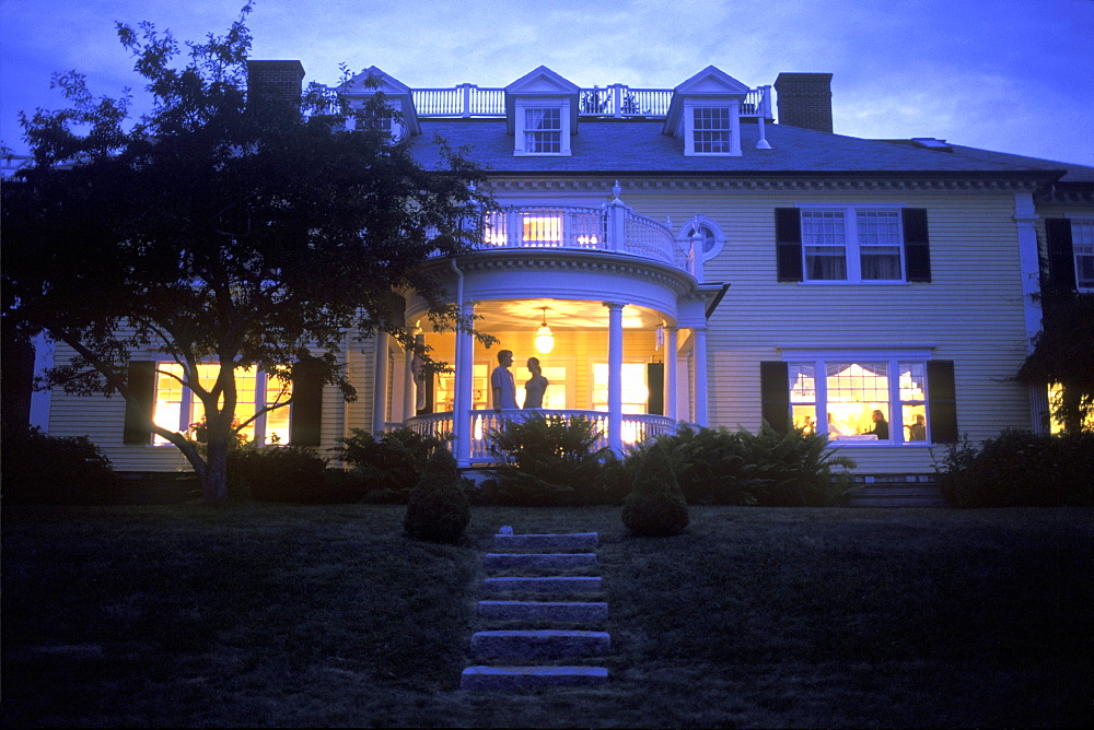 A couple takes in the evening air at Dark Harbor House on Isleboro, Maine.