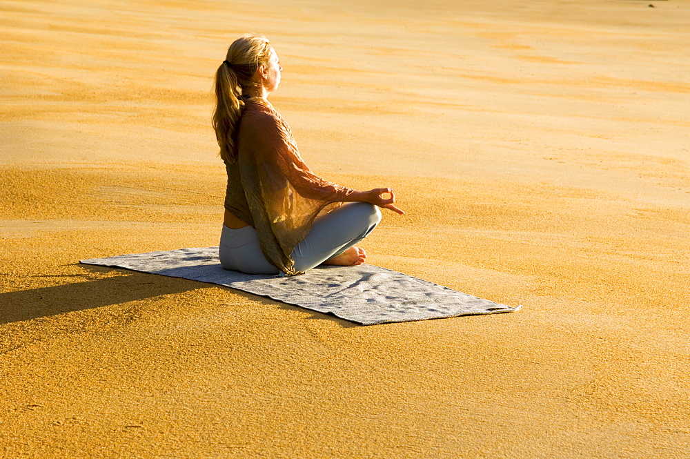 Katrin Schneider practicing yoga on a beach in Abel Tasman National Park. South Island, New Zealand.