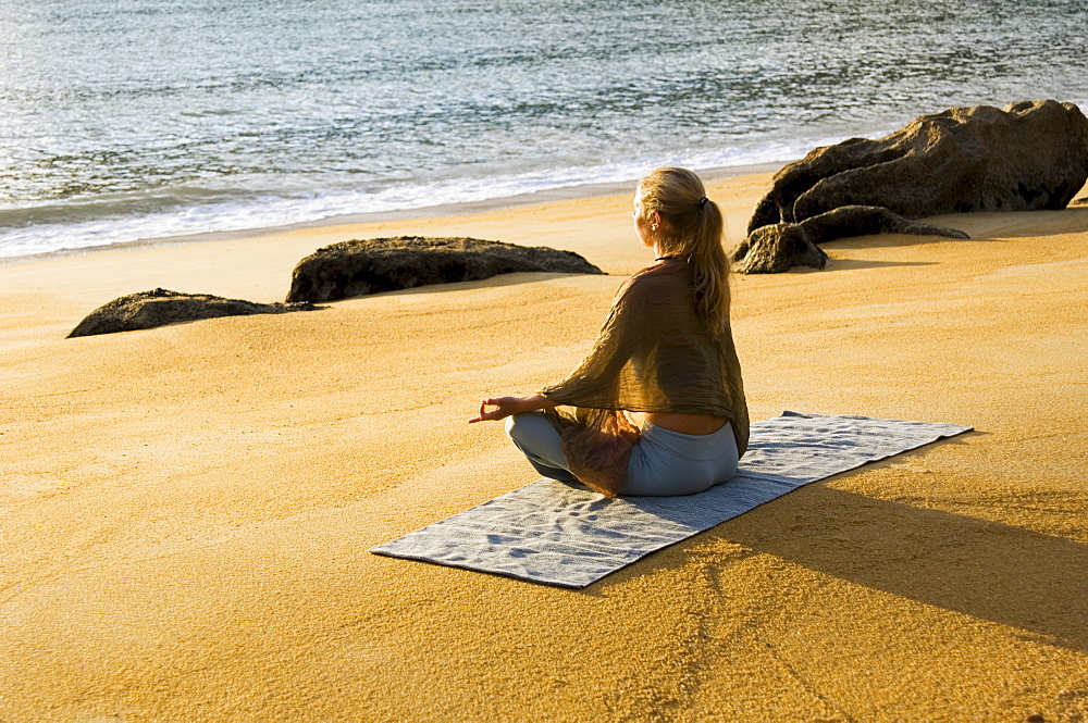 Katrin Schneider practicing yoga on a beach in Abel Tasman National Park. South Island, New Zealand.