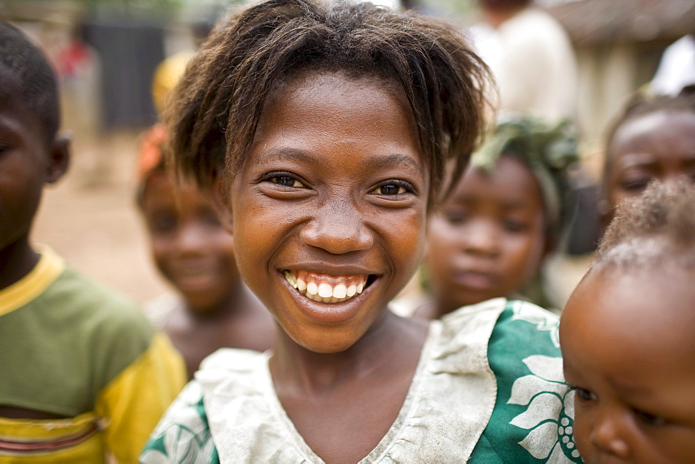 Young girl smiling. Gbolokai is a small town of a few hundred people 20 minutes off the main road near Totota, all of its inhabitants fled during the long brutal civil war and have slowly returned after 2005 to try and rebuild their lives.