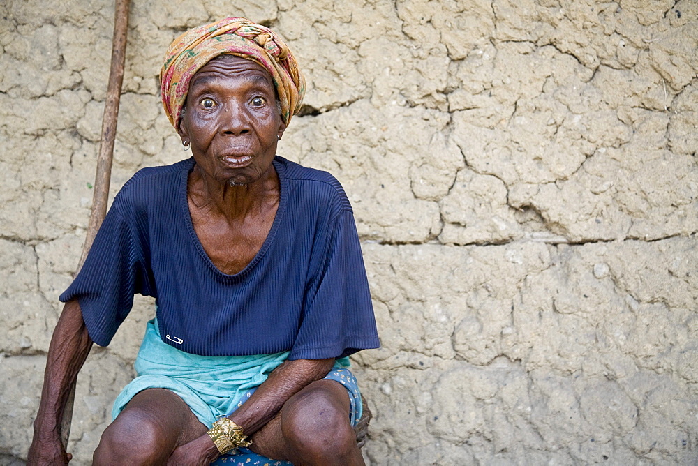 Elderly woman making a funny face. Sulima is a fishing village on the Alantic coast at the mouth of the Moa River near the Liberian border.  Along its pristine beach, one of the longest in West Africa, fishermen launch dugout canoes and fish with nets drag back manually from the shore. Larger power boats mainly from Ghana leave from the more sheltered harbour on the Moa River. Most of the fish is smoke dried by the women of the village and then sold in markets as far off as Monrovia, Liberia.