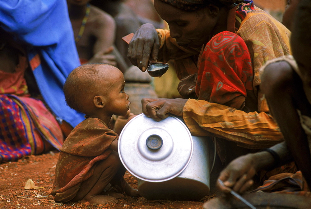 Malnourished mother and child share a little food at distribution in Baidoa, Somalia.