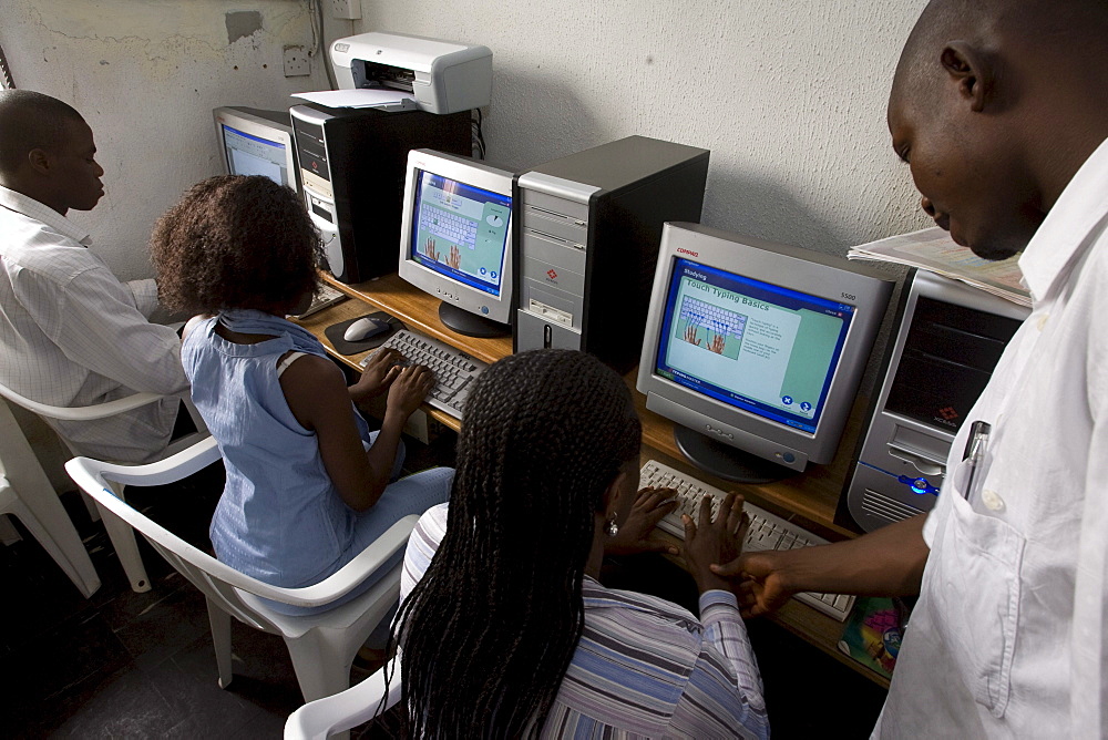 A computer training institute in Lagos, Nigeria. The Pentium 2 computers were bought second hand in Nigeria and there are about 16 computers at this location. Students are learning various software programs including typing, Microsoft word and a drawing program. One student in the striped shirt is Alice Itodo.