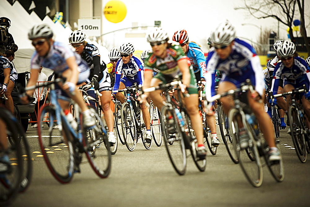 Front view of a pack of female bicycle racers in the Amgen Tour of California, downtown Santa Rosa, California.