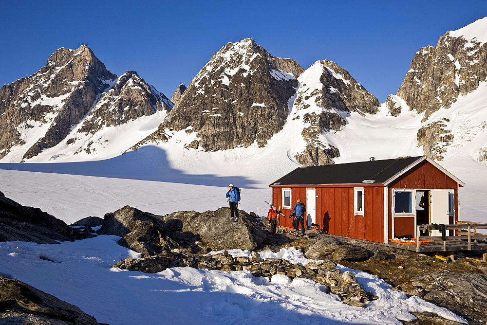 A group of adventure skiers relax at a mountain hut near the Karale Glacier on Ammassalik Island, Greenland.