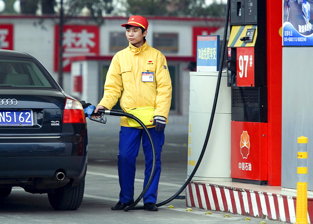 A Chinese gas station attendant fills up a customer's car in Beijing. Chinese Premier Wen Jiabao promised a national plan to address climate change but avoided offering emissions caps, speaking after a parliament session where global warming barely scraped onto the agenda.