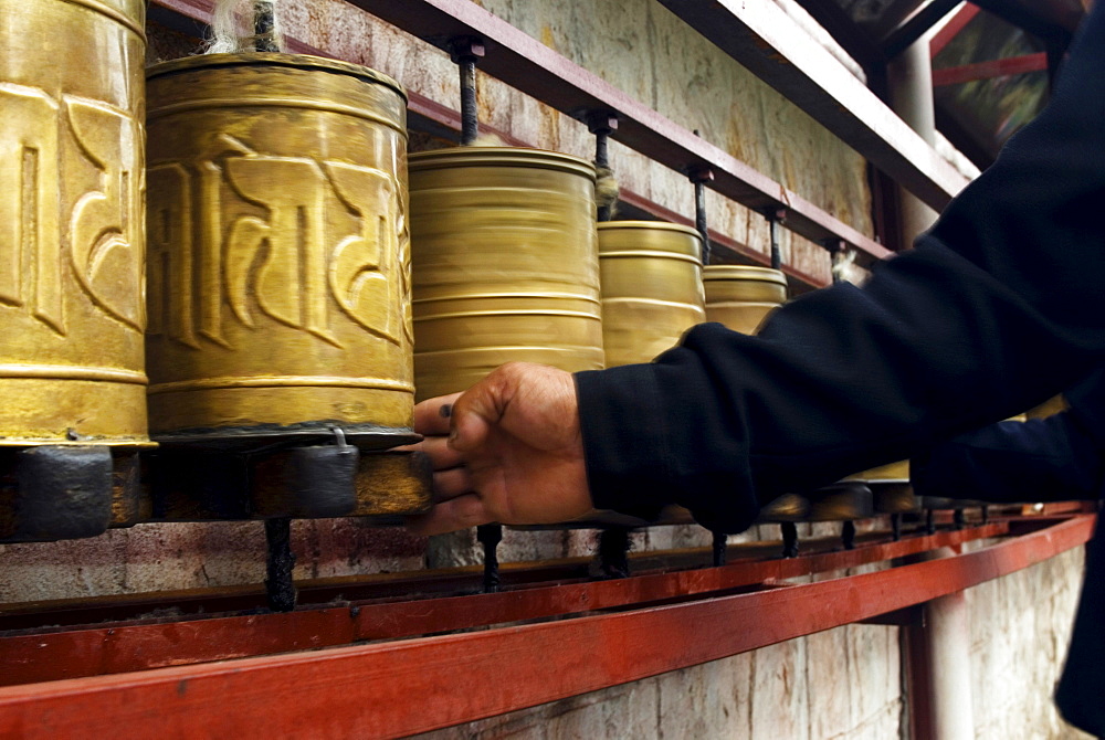 A Tibetan pilgrim spins prayer wheels in Lhasa, Tibet Autonomous Region, China.