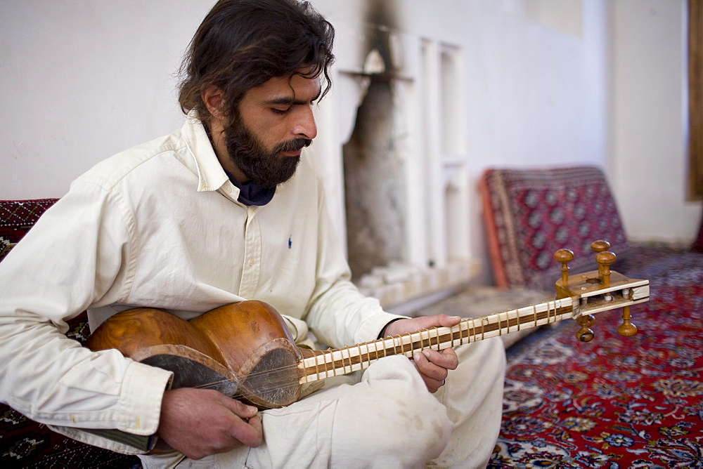 Garmeh, Iran - February, 2008: Iranian man playing traditional guitar like instrument.