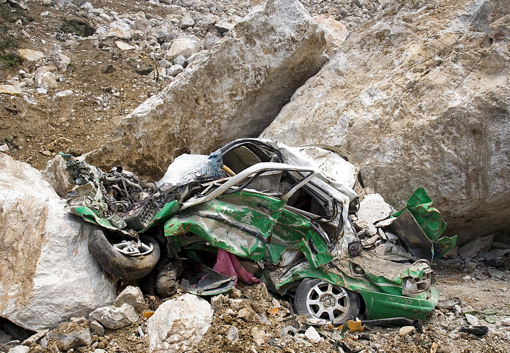 A small vehicle is smashed beyond recognition after being hit by large bounders in Beichuan Town, which was severely damaged by a powerful 7.9 earthquake. The Chinese government raised the death toll to 21,500 but has said fatalities could rise above 50,000. Tens of thousands could still be buried in collapsed buildings in Sichuan province, where the quake was centered.