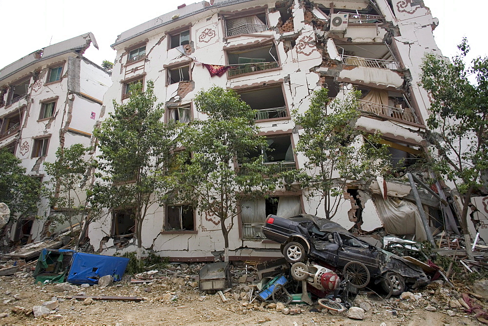 A mangles car is seen in front of a partially collapsed building in Beichuan Town, which was severely damaged by a powerful 7.9 earthquake. The Chinese government raised the death toll to 21,500 but has said fatalities could rise above 50,000. Tens of thousands could still be buried in collapsed buildings in Sichuan province, where the quake was centered.