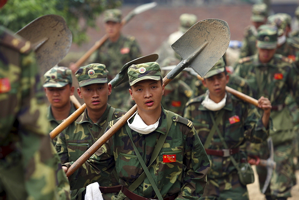 Chinese military descend upon Beichuan town to provide relief after Monday's earthquake. The Chinese government raised the death toll to 21,500 but has said fatalities could rise above 50,000. Tens of thousands could still be buried in collapsed buildings in Sichuan province, where the quake was centered.