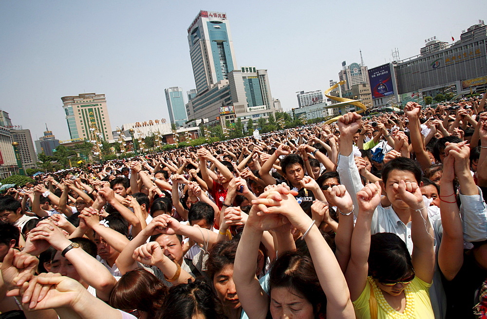 Chinese mourners hold hands in the central square of Chengdu as they observe three minutes of silence to grieve Sichuan's earthquake victims.