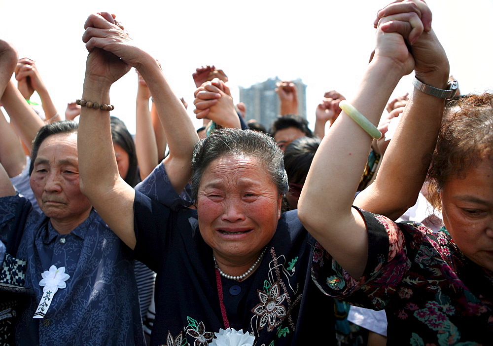 Chinese mourners hold hands in the central square of Chengdu as they observe three minutes of silence to grieve Sichuan's earthquake victims.