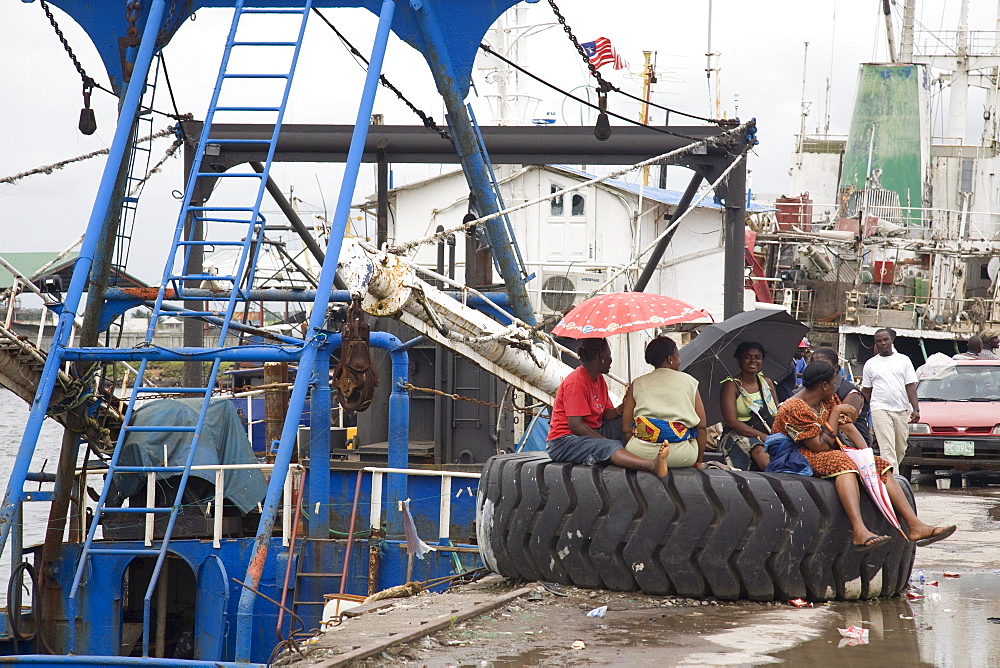 Monrovia, Liberia - September 19, 2007: Liberian women hanging out on the fishing port in Monrovia where almost all of the boats are operated by foreigners.