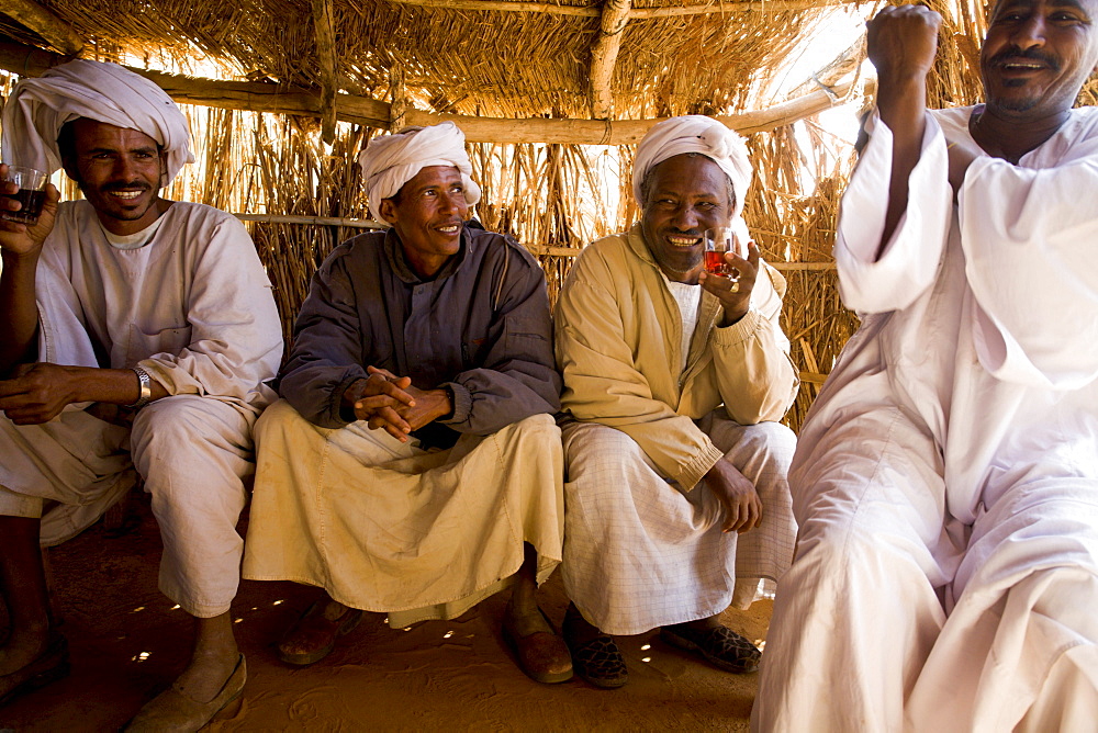 Camel traders and herders sit in a tea hut in a camel market in El Obeid, Sudan on February 16, 2006. Yussuf Gamaa, 2nd from L, is a camel herder from Darfur. About 150,000 camels cross over from Sudan into Egypt every year, the majority as cattle as an inexpensive source of protein. Today the camel is both the caravan and the cargo. Camels from this market will travel the Forty Days Road or Darb el-Arbein a 1,200 mile desert trail into Egypt and the oldest trade route in the Sahara. Desert nomads like Yussuf depend on the profitable camel trade for their livelihood.