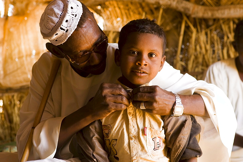 Camel broker Elsean Ahmed Naiem with his son Ali Mohammed Abo in a tea hut at the camel market in El Obeid, Sudan.