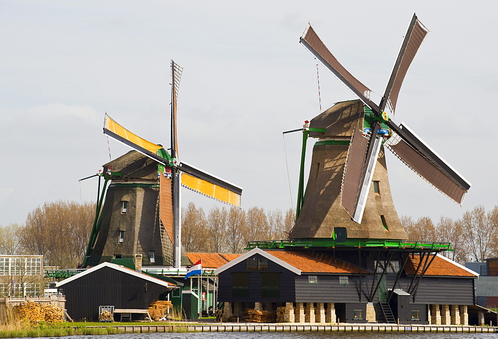 Windmills along a river in at Zaansche Schans, Netherlands.