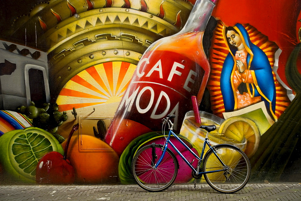 Bicycle sits next to painted wall in downtown Den Haag, The Netherlands.