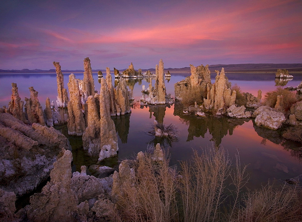 Tufa formations, towering remnants created by the upwelling of mineral deposits that formed underwater, make for an interesting and otherworldly scene at twilight along the shore of California's Mono Lake.