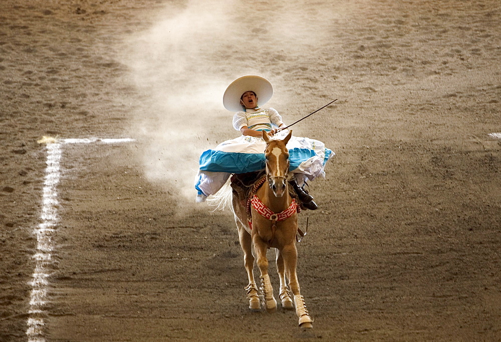 An Amazona rides her horse at an Escaramuza competition in Mexico City, May 24, 2008. Escaramuzas are similar to US rodeos, where female competitors called "Amazonas" wear long skirts, and ride side saddle. Male rodeo competitors are "Charros," from which comes the word "Charreria." Charreria is Mexico's national sport.