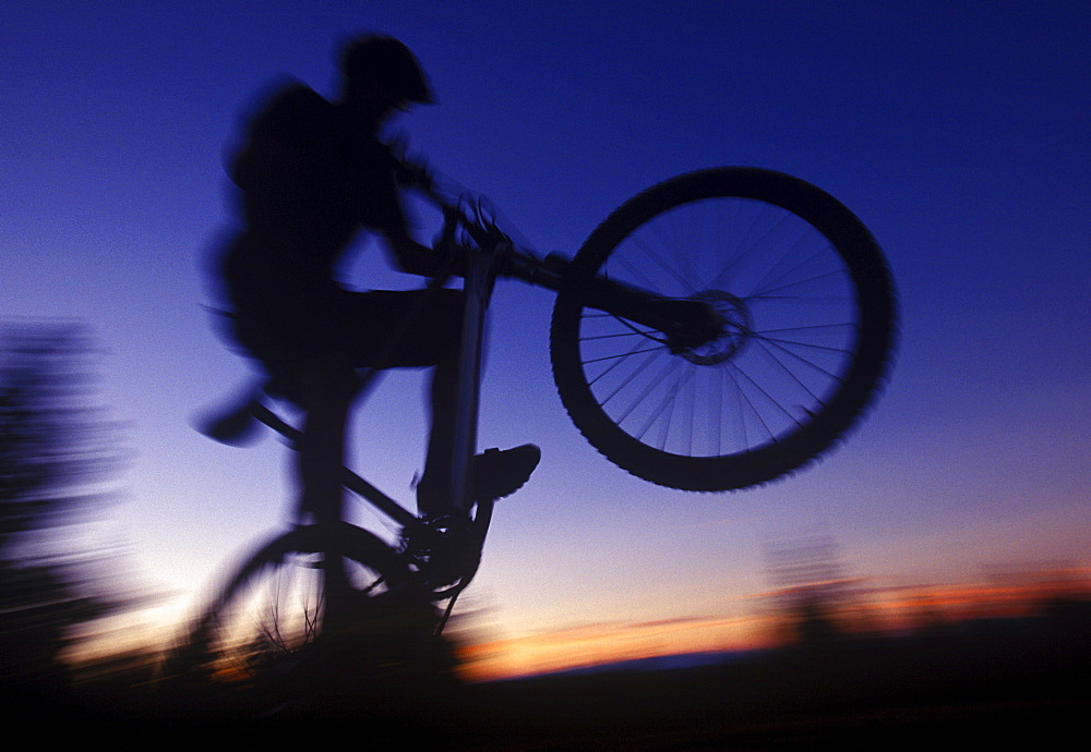 A mountain bike rider silhouetted against the setting sun in Washington's Cascade Mountains.