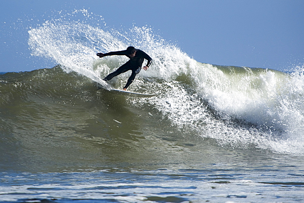 One male surfer carving aggressively on a wave.