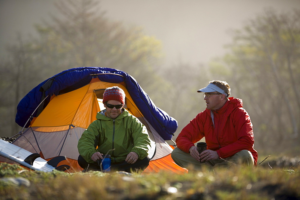 Two men sit outside their tent on The Lost Coast, California.