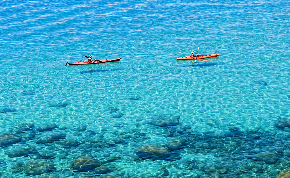 A pair of kayakers is out for a morning paddle along the pristine shores of Lake Tahoe, Nevada.