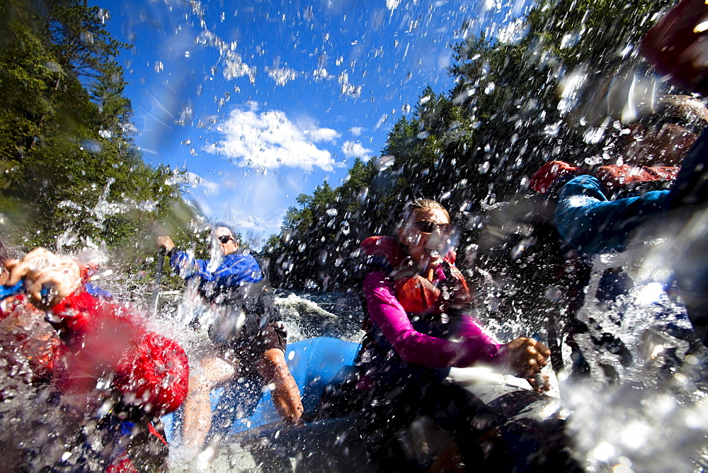 A group of adults whitewater rafting in Maine.