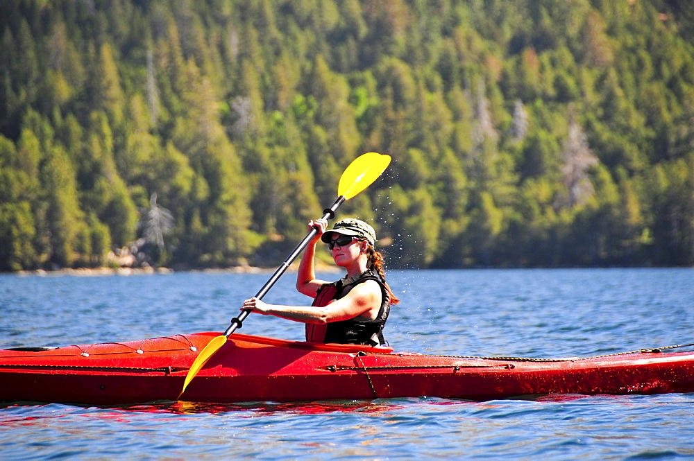 A woman kayaks on Caples Lake near Kirkwood, California in the summer.