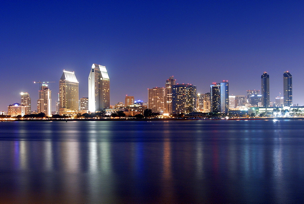 The San Diego skyline is illuminated at dusk as seen from Coronado Island, CA.