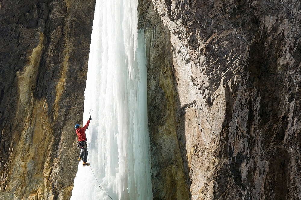 A man ice climbing a  frozen waterfall called Whorehouse Ice Hose, Silverton, Colorado.