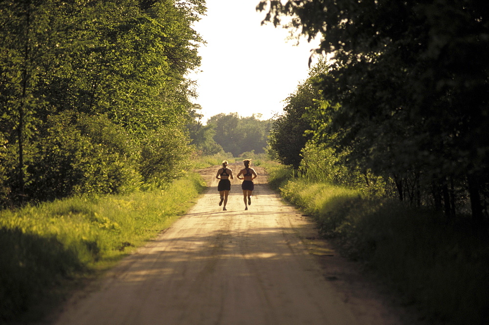 Runners on dirt road jogging.