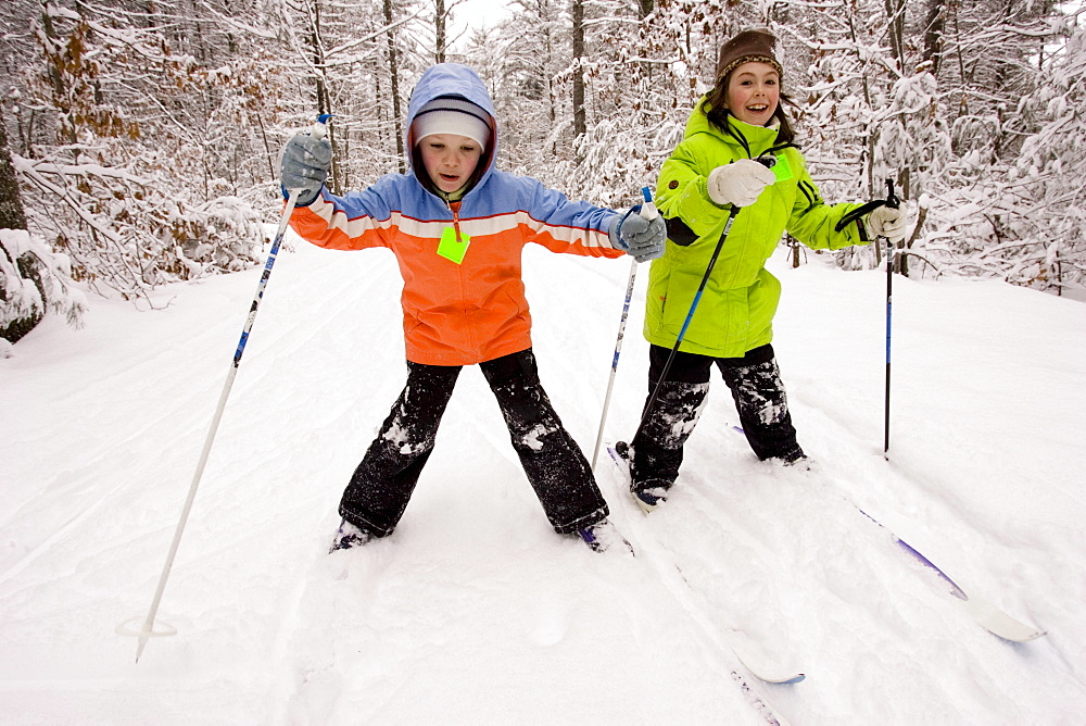 Two young girls Cross Country Skiing in Dayton, Maine.