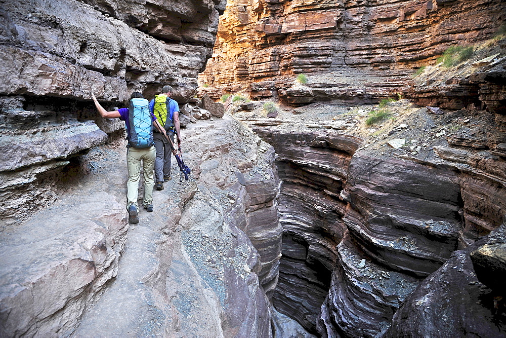 Hikers walk along Deer Creek Narrows in the Grand Canyon outside of Fredonia, Arizona November 2011.  The 21.4-mile loop starts at the Bill Hall trailhead on the North Rim and descends 2000-feet in 2.5-miles through Coconino Sandstone to the level Esplanada then descends further into the lower canyon through a break in the 400-foot-tall Redwall to access Surprise Valley.  Hikers connect Thunder River and Tapeats Creek to a route along the Colorado River and climb out Deer Creek.