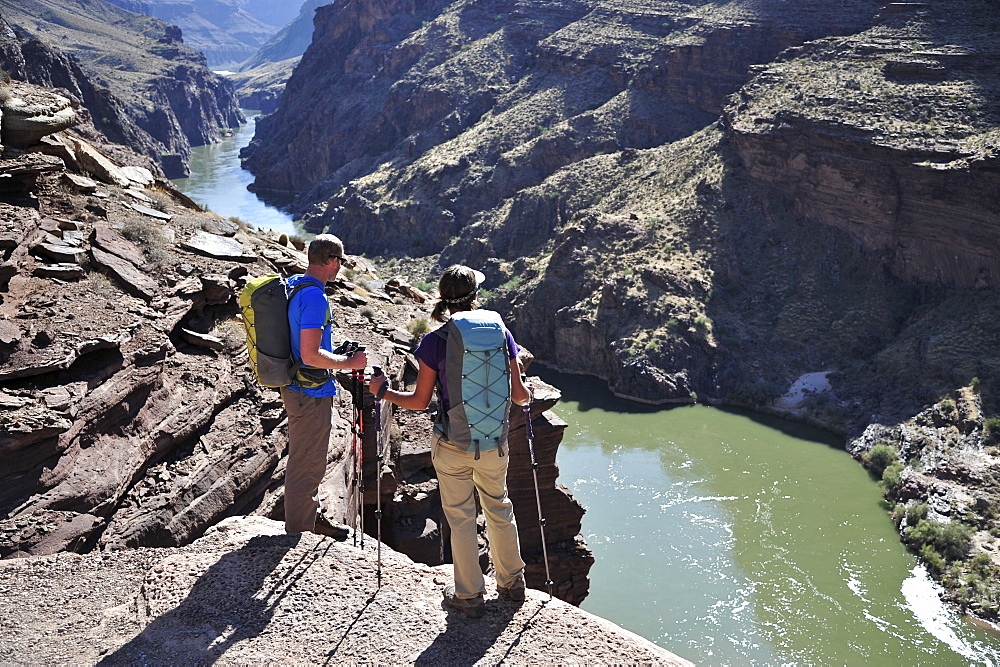 Hikers overlook the Colorado River as they exit the Deer Creek Narrows in the Grand Canyon outside of Fredonia, Arizona November 2011.  The 21.4-mile loop starts at the Bill Hall trailhead on the North Rim and descends 2000-feet in 2.5-miles through Coconino Sandstone to the level Esplanada then descends further into the lower canyon through a break in the 400-foot-tall Redwall to access Surprise Valley.  Hikers connect Thunder River and Tapeats Creek to a route along the Colorado River and climb out Deer Creek.