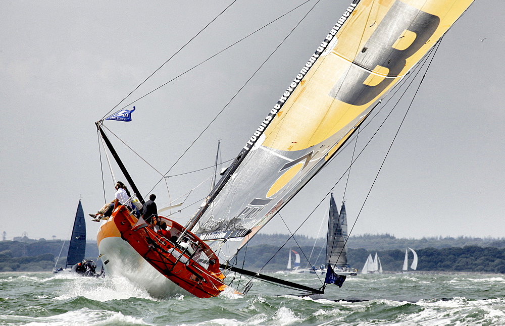 The IMOCA Open 60 PRB crewed by Vincent Riou and Jean Le Cam racing and winning the around the Isle of Wight Artemis Challenge, Cowes, England.