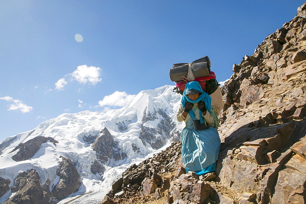 An Aymaran women porters carry loads of climbing gear at 16,000ft on Illimani a 20,000ft peak in the Bolivian Andes.