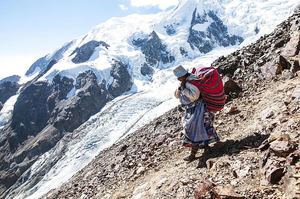 An Aymaran women porters carry loads of climbing gear at 16,000ft on Illimani a 20,000ft peak in the Bolivian Andes.