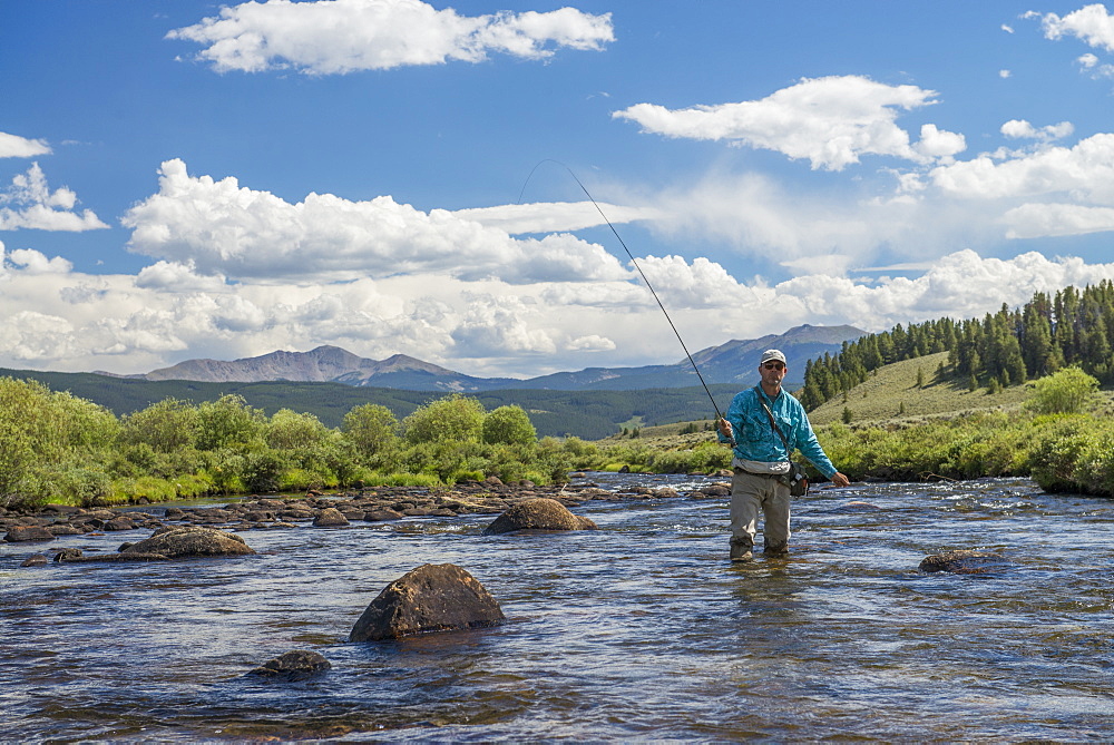 Wading through the river for the next hole high in the mountains of Colorado, Colorado, USA